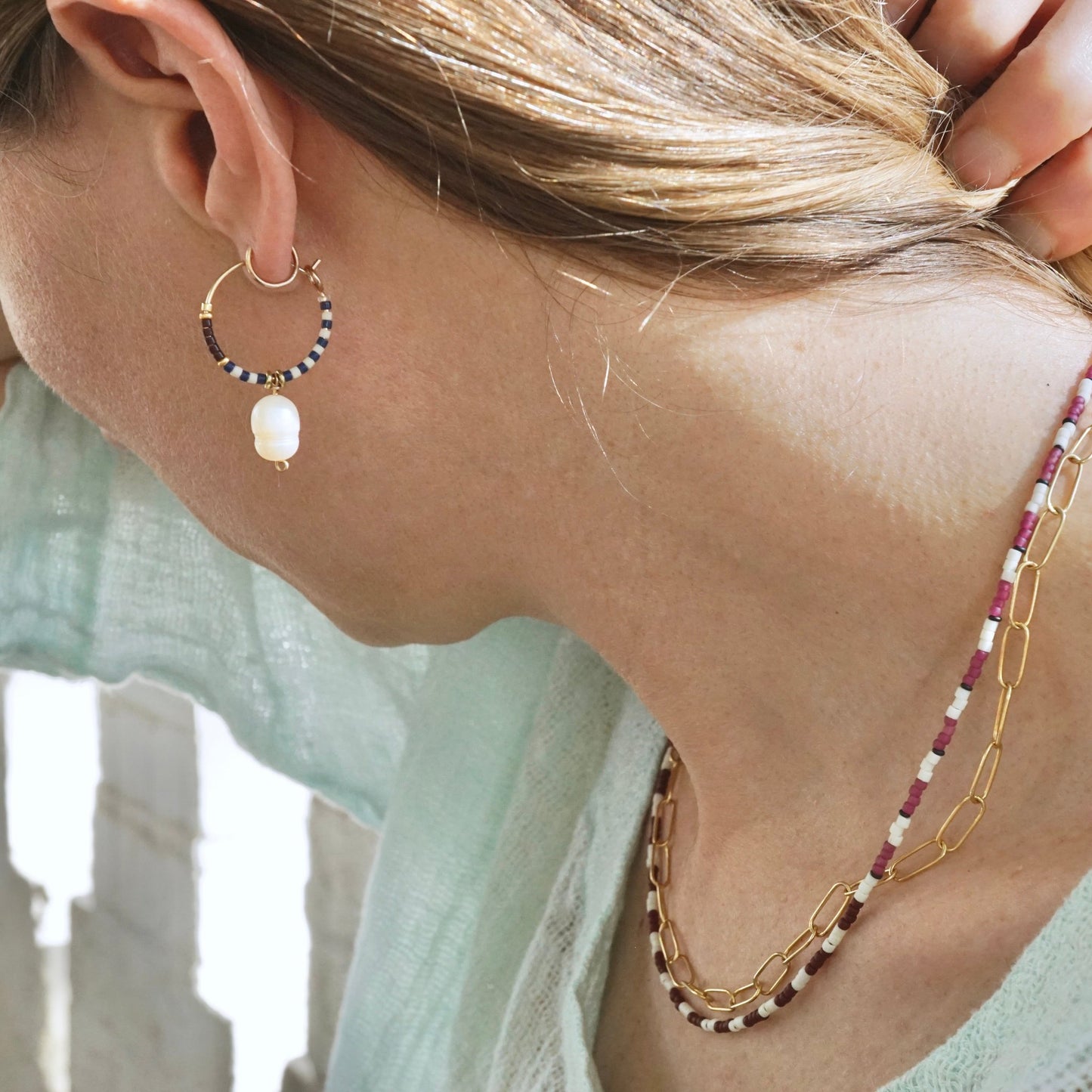 model wearing hoop earring with pearl drop
