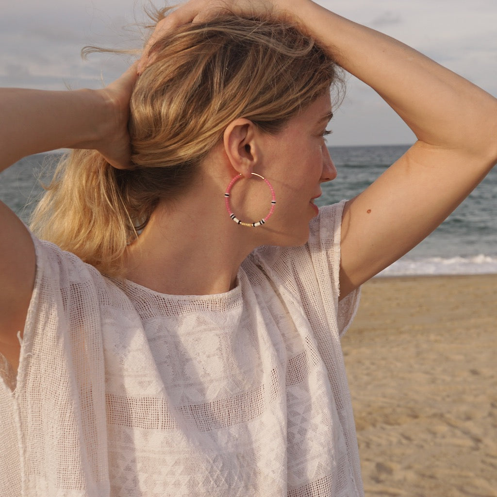model on beach wearing 2" beaded hoops