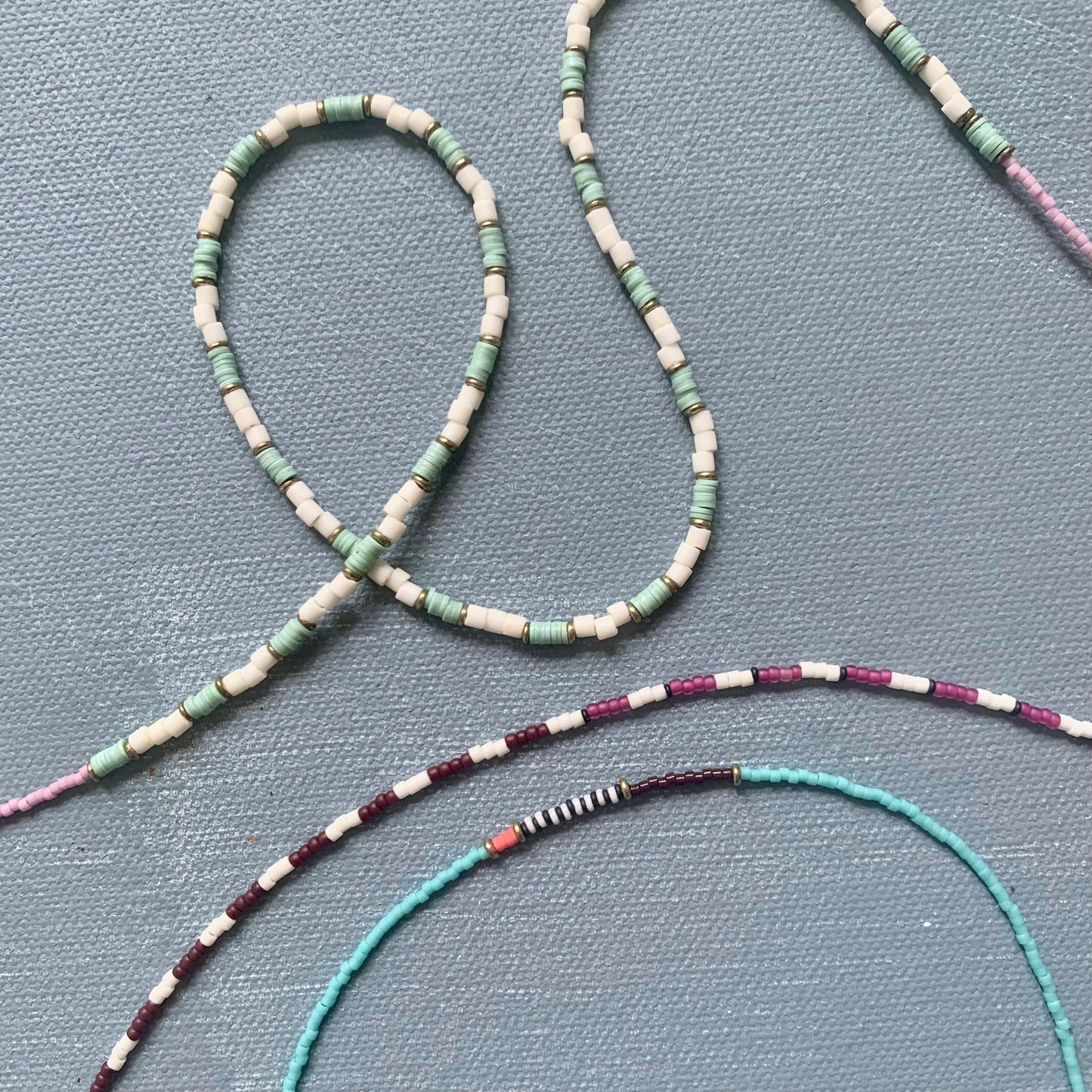 assorted beaded necklaces displayed on blue background