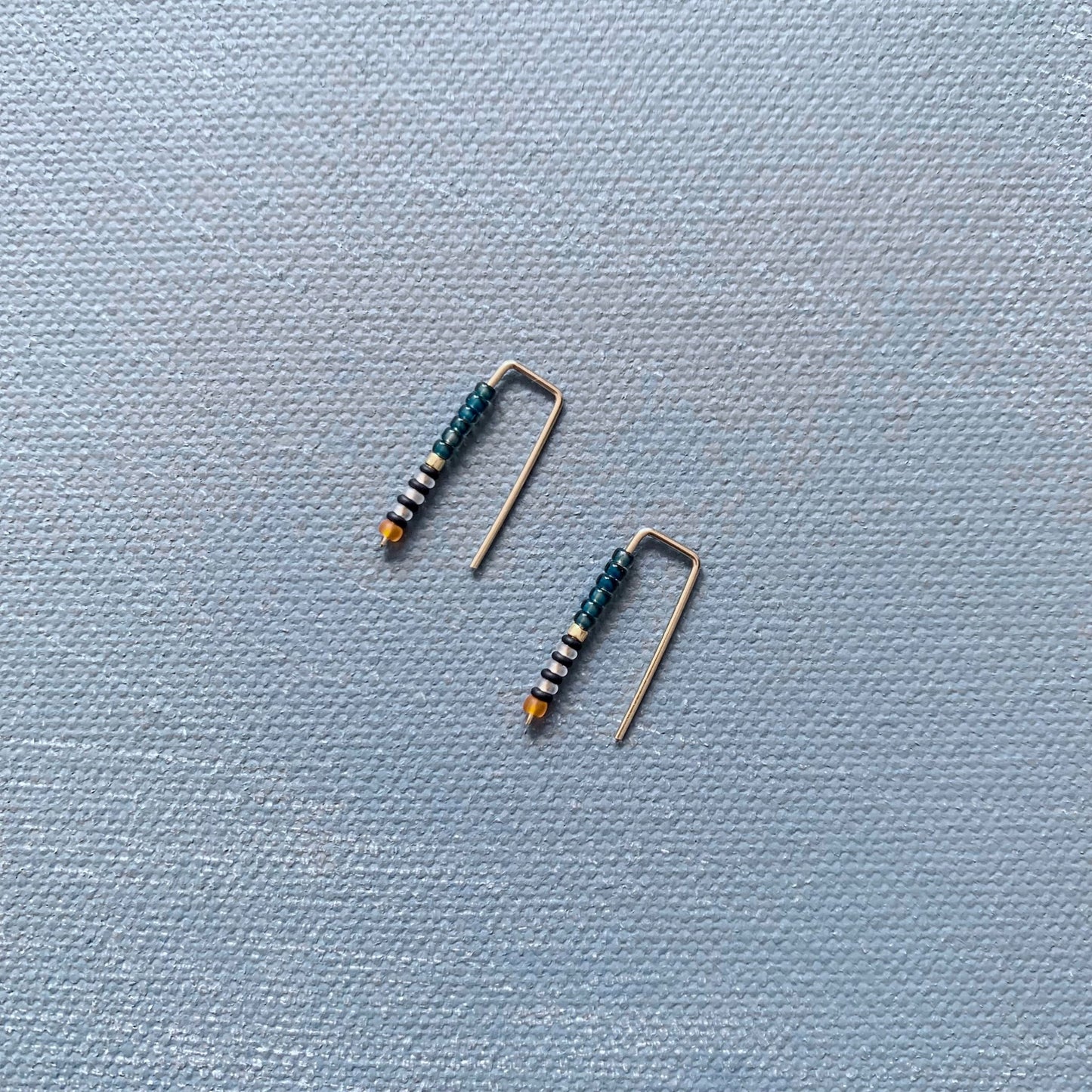 small handmade staple earrings in teal blue