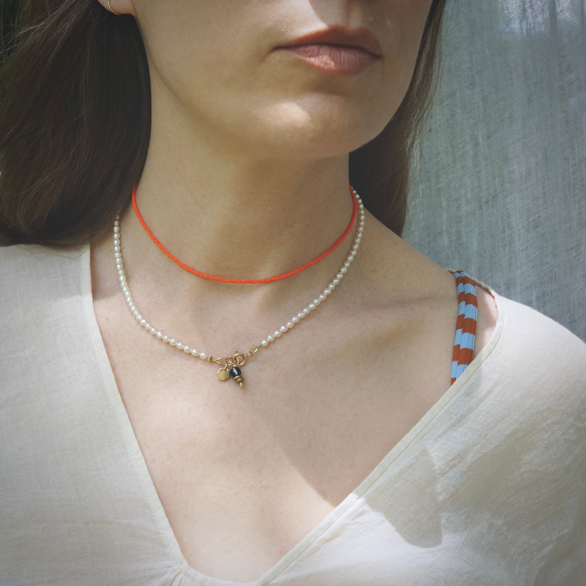 stack of 2 beaded necklaces on model