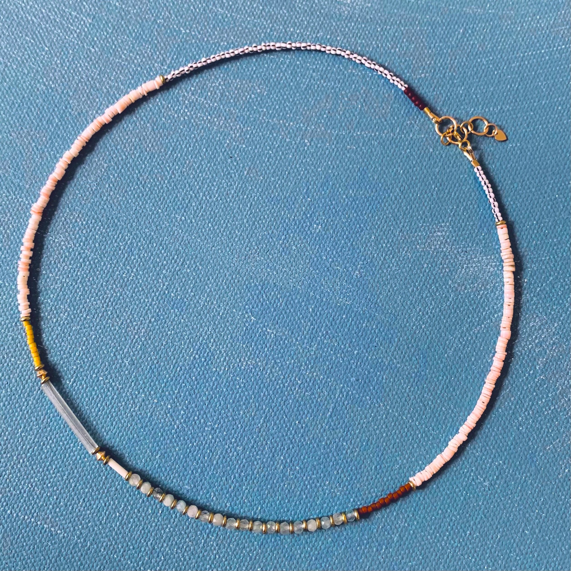 beaded gemstone necklace with aquamarine shown on blue background