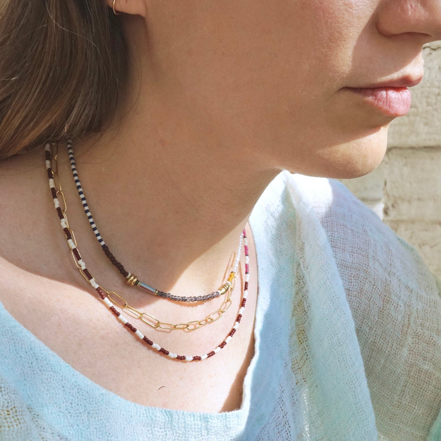 model wearing three layered necklaces
