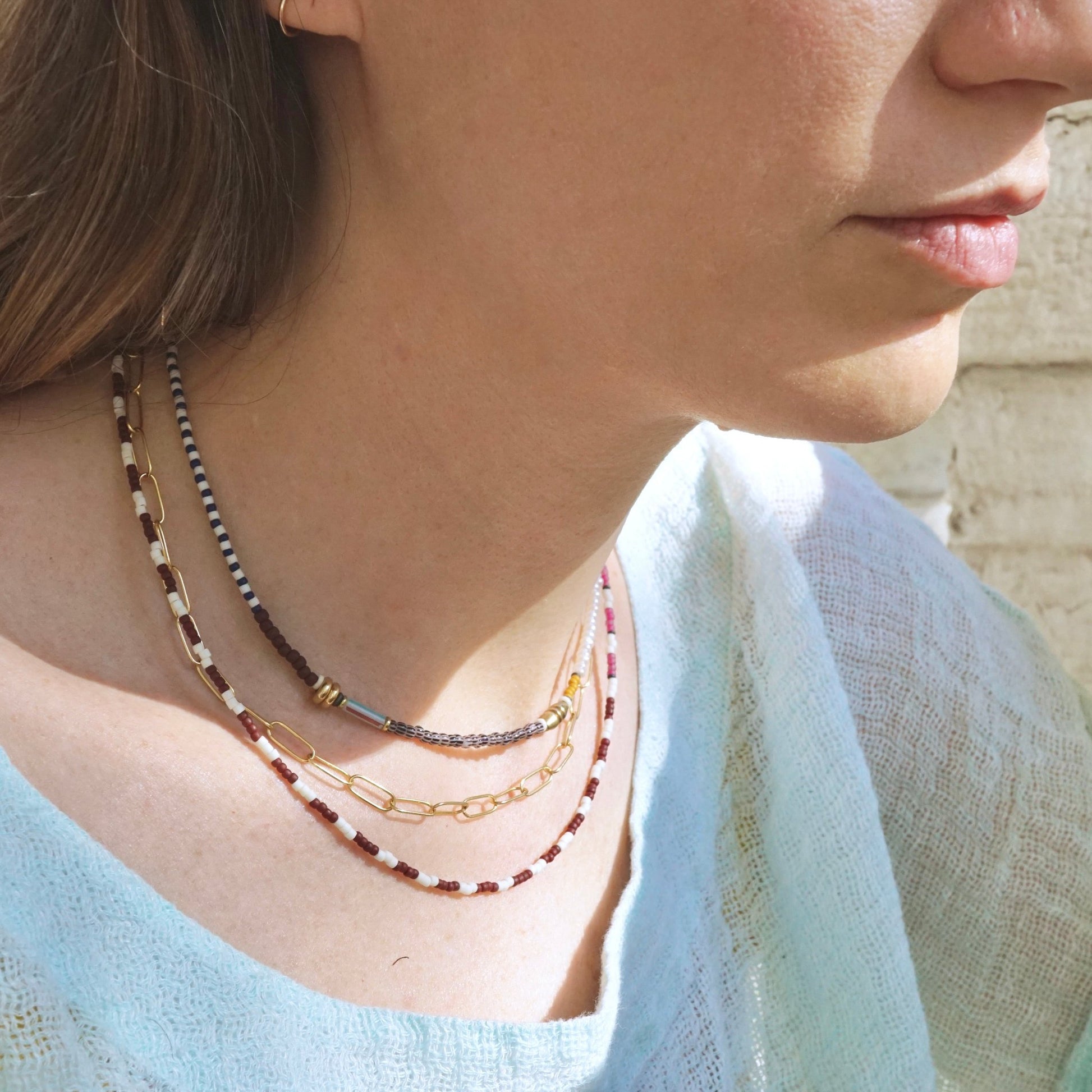 model wearing three layered necklaces