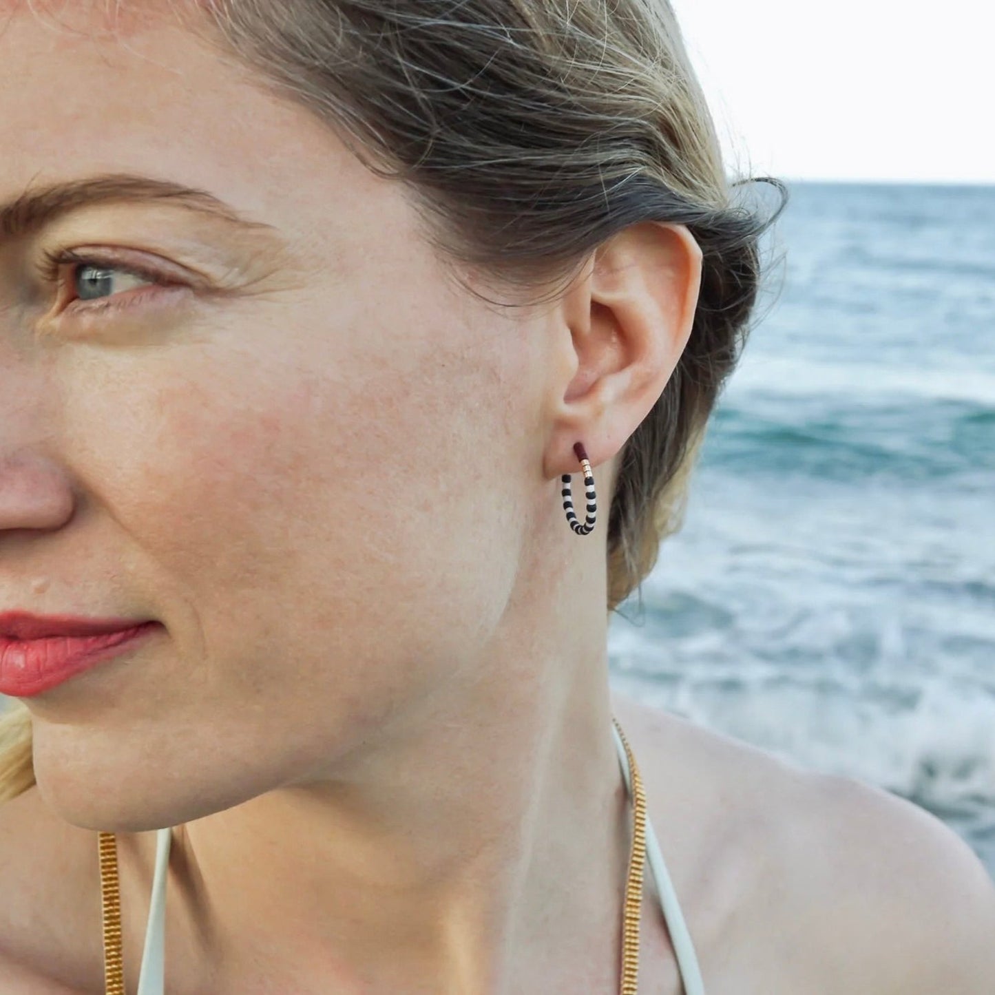 model wearing small beaded hoop earrings